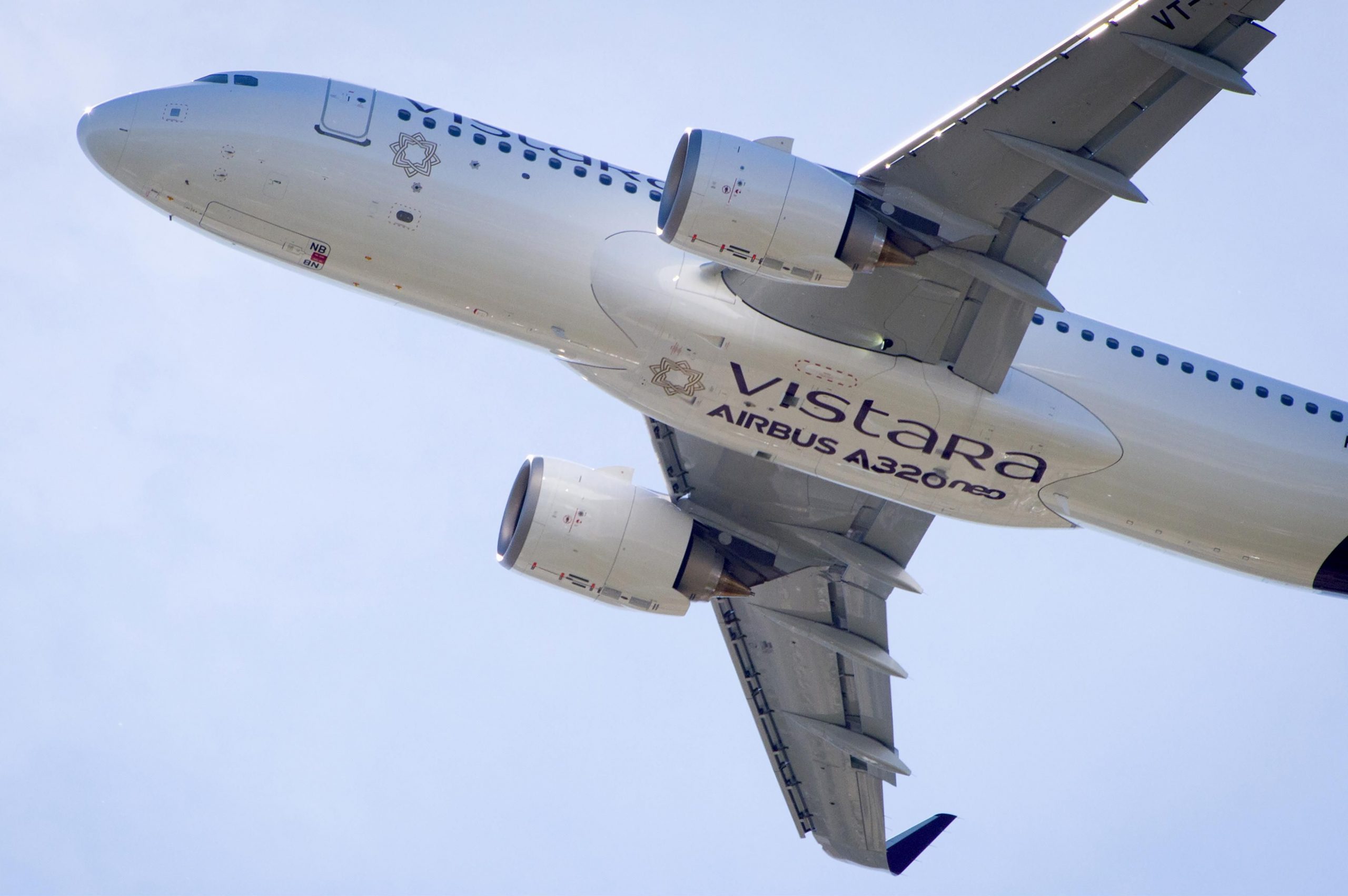 A Vistara A320neo climbs overhead.