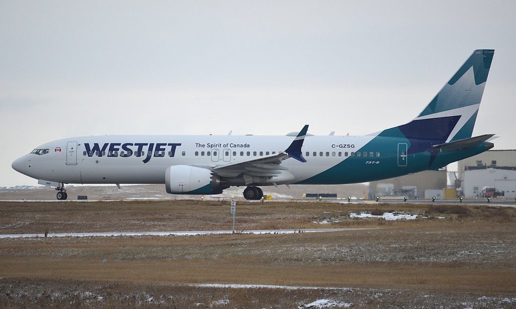A WestJet Boeing 737 MAX lines up on the runway.