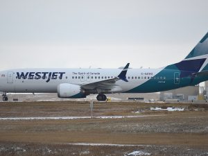 A WestJet Boeing 737 MAX lines up on the runway.