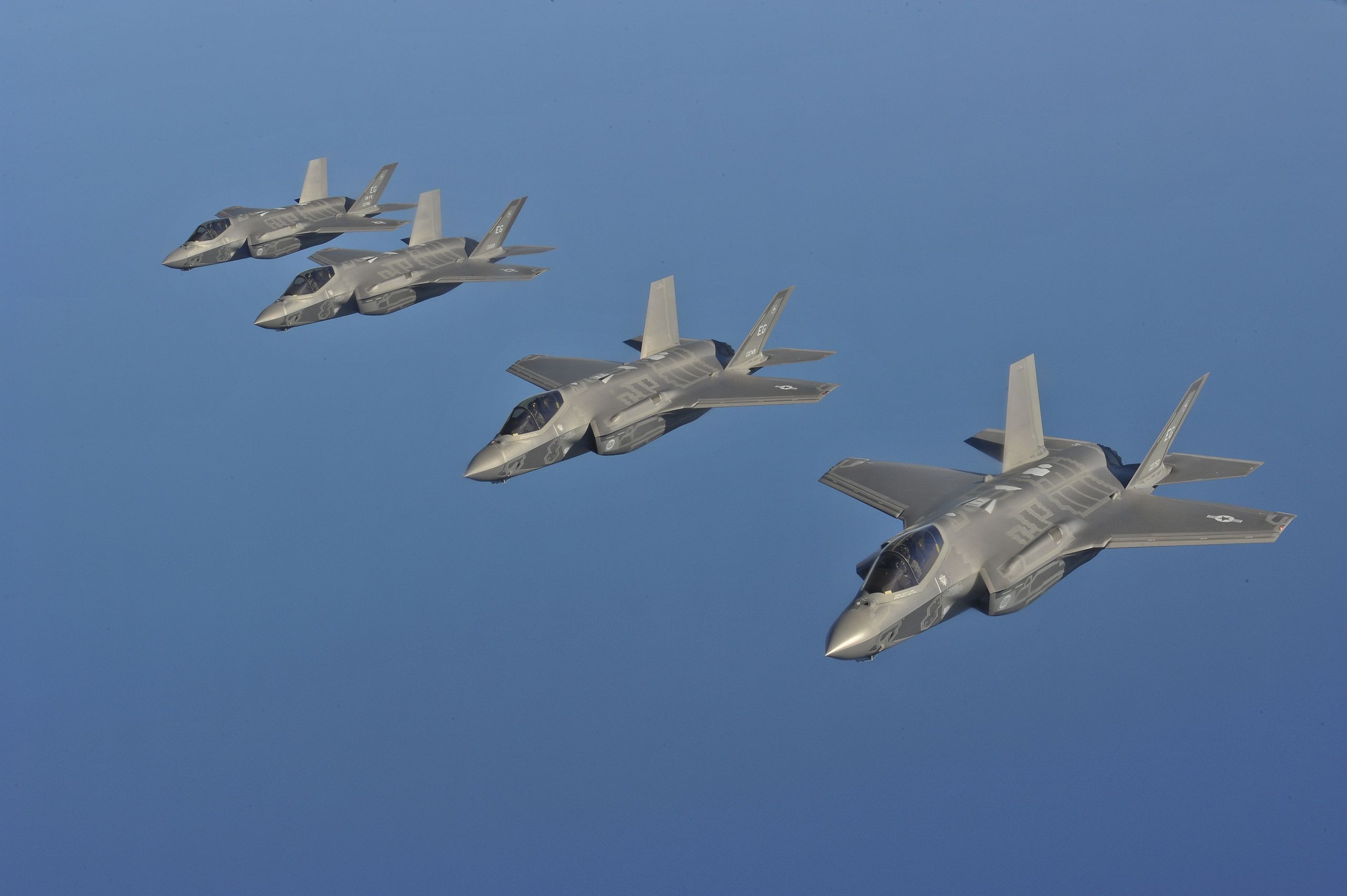 Four F-35A Lightnining fighter jets in formation flight.