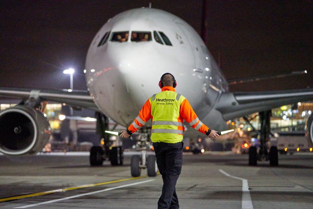 An aircraft is marshalled to a parking bay at Heathrow airport.