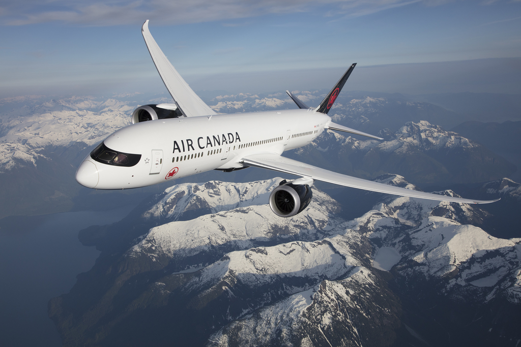 An Air Canada 787-9 Dreamliner flies over the Rocky Mountains.