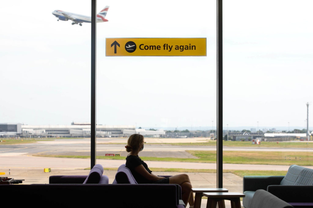 A passenger at the window of London Heathrow Airport terminal