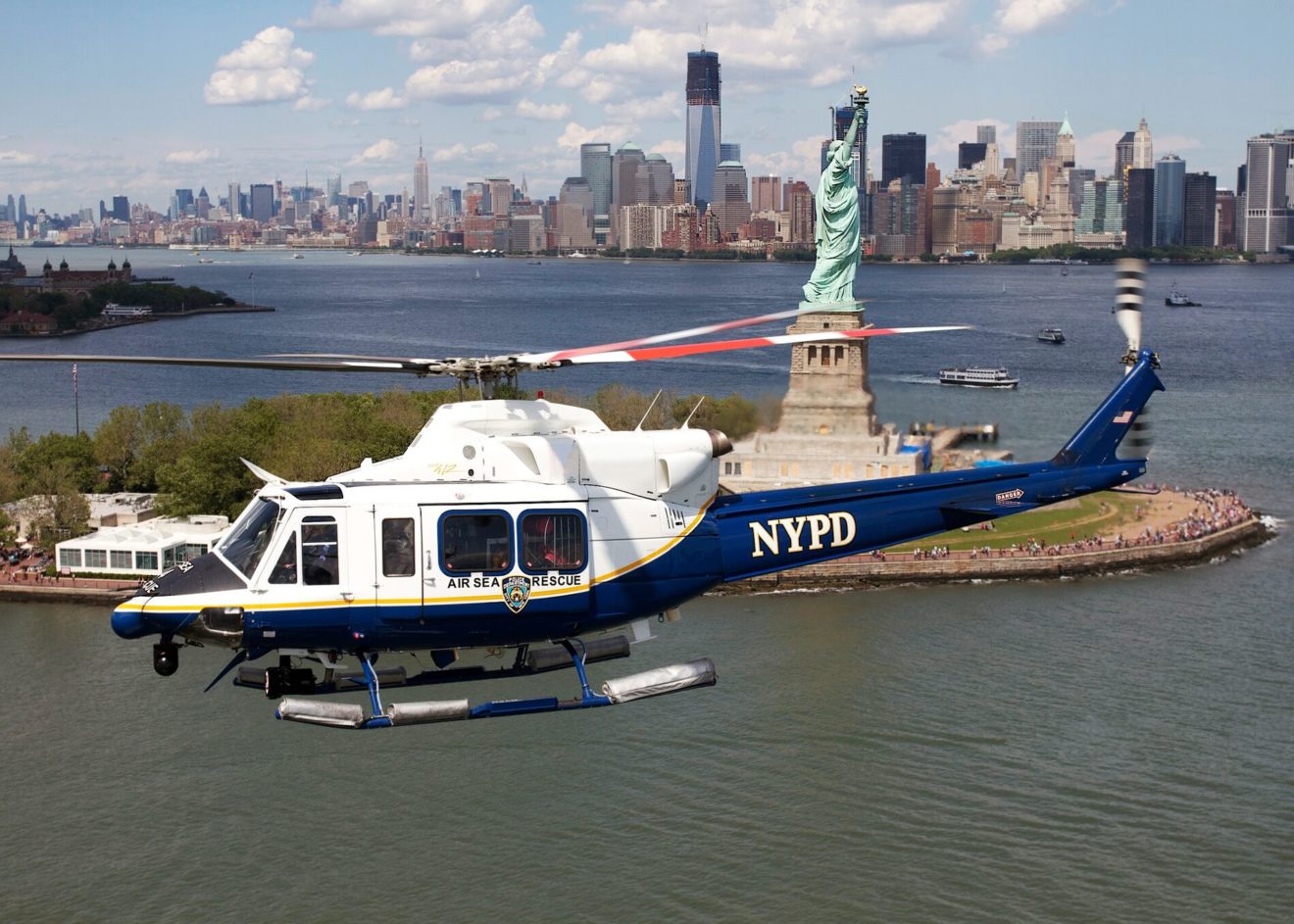 NYPD Bell helicopter flying past the Statue of Liberty.