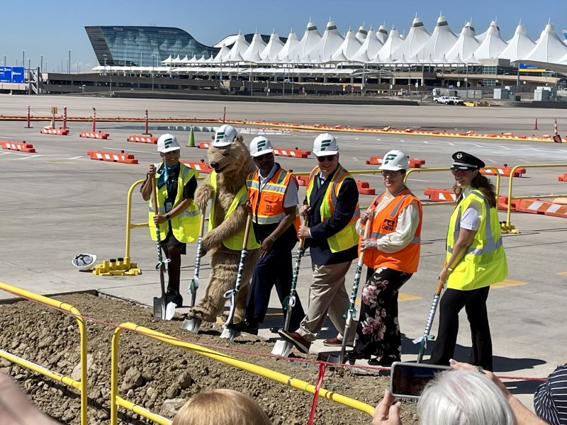 Frontier Airlines and Denver Airport staff laying new foundation at airport.