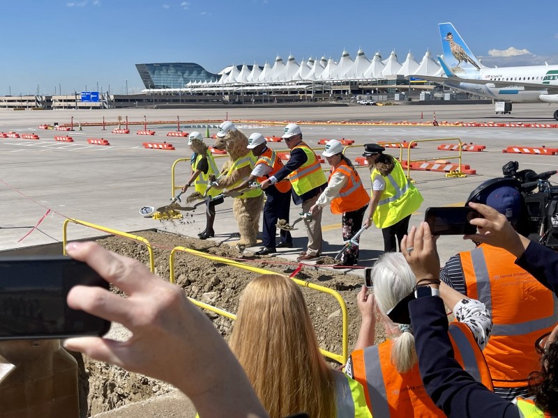 Frontier Airlines and Denver Airport staff laying new foundation at airport.