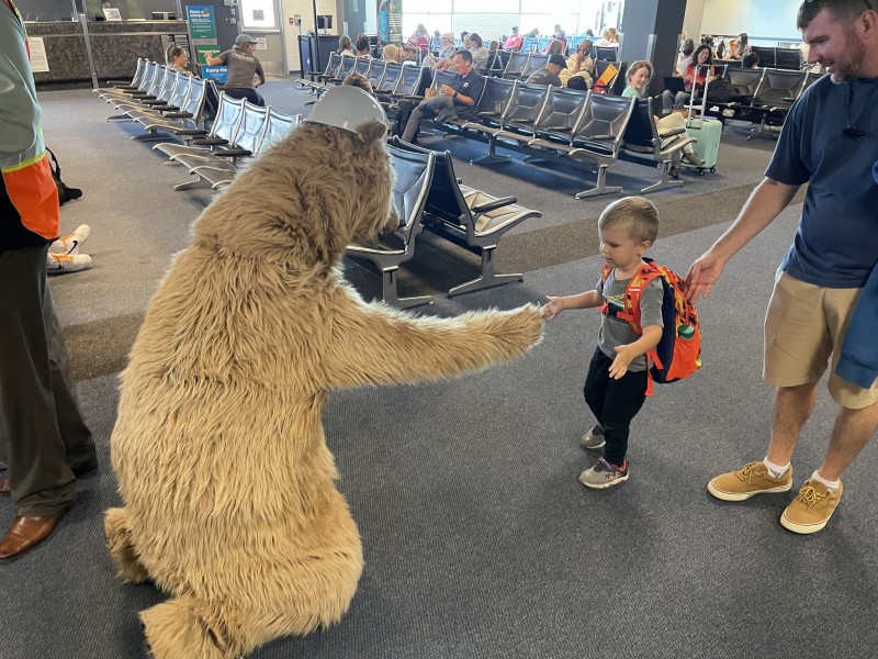 Mascot Griz the Bear shakes a little kid's hand.