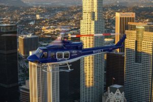 Subaru Bell helicopter 412EPX in flight over city skyline.