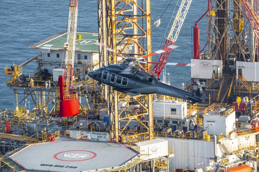 A Bell 525 helicopter landing an an oil rig helipad.