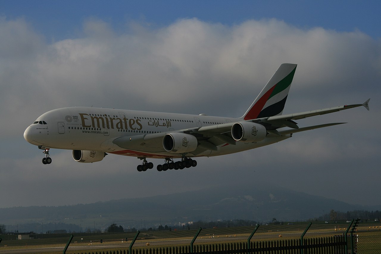 An Emirates A380 approaching to land on a cloudy day.