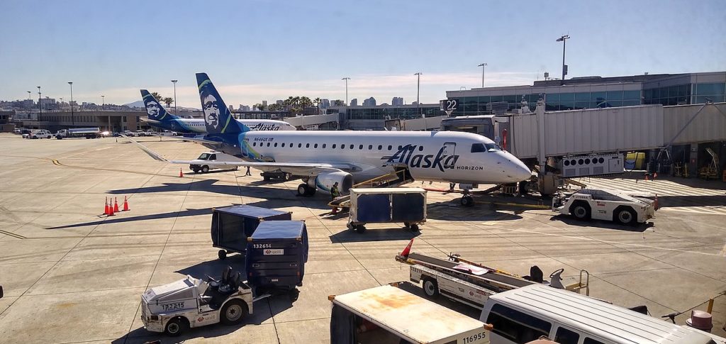 An Alaska Airlines Embraer aircraft parked at the terminal building