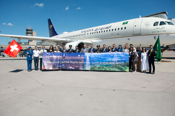 SAUDIA staff with banner celebrating new route to Zurich airport from Riyadh