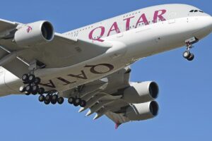 Close up of a Qatar Airways A380 in flight with wheels down.