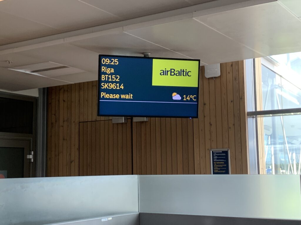 The airBaltic departure screen in the terminal building.