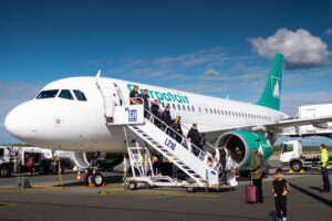 Passengers exit a Carpatair flight onto the yarmac.