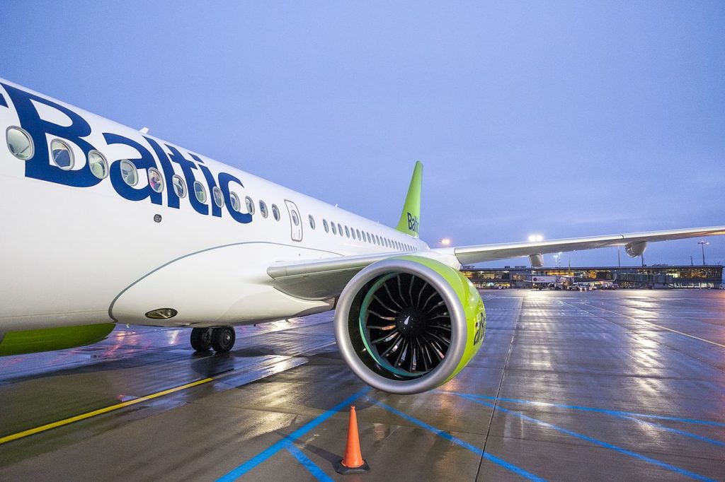 An airbaltic aircraft preparing for departure in overcast evening conditions.