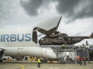 An Airbus Beluga military transport loading a helicopter.