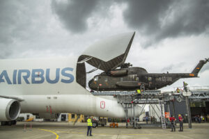 An Airbus Beluga military transport loading a helicopter.