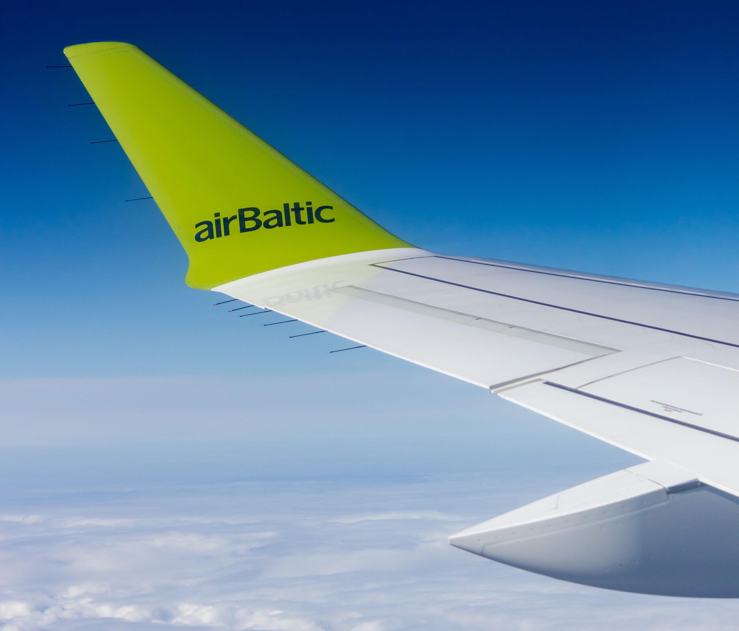 A view across the wing of an airBaltic A220 in flight.