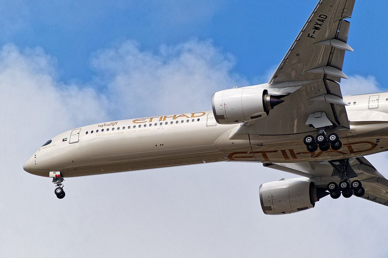 An underside view of an Etihad Airways A350 on approach to land.