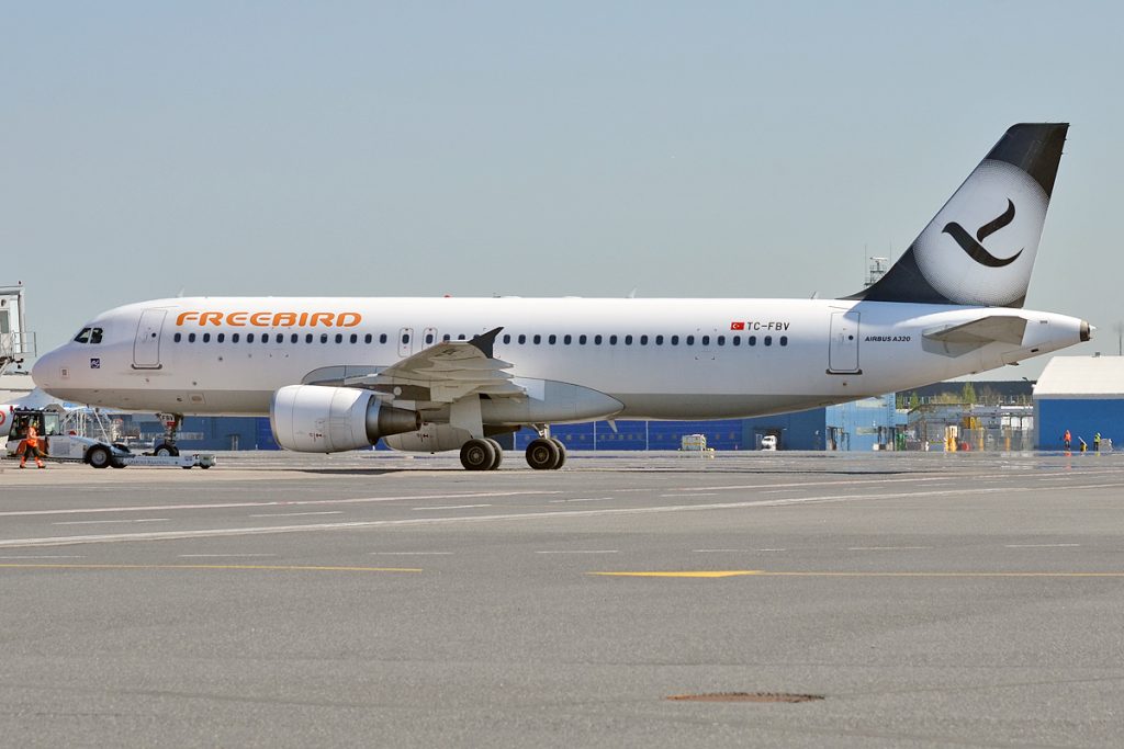 Freebird Airlines Airbus A320 parked at the terminal.