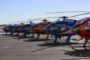 A parked line of MD530 helicopters