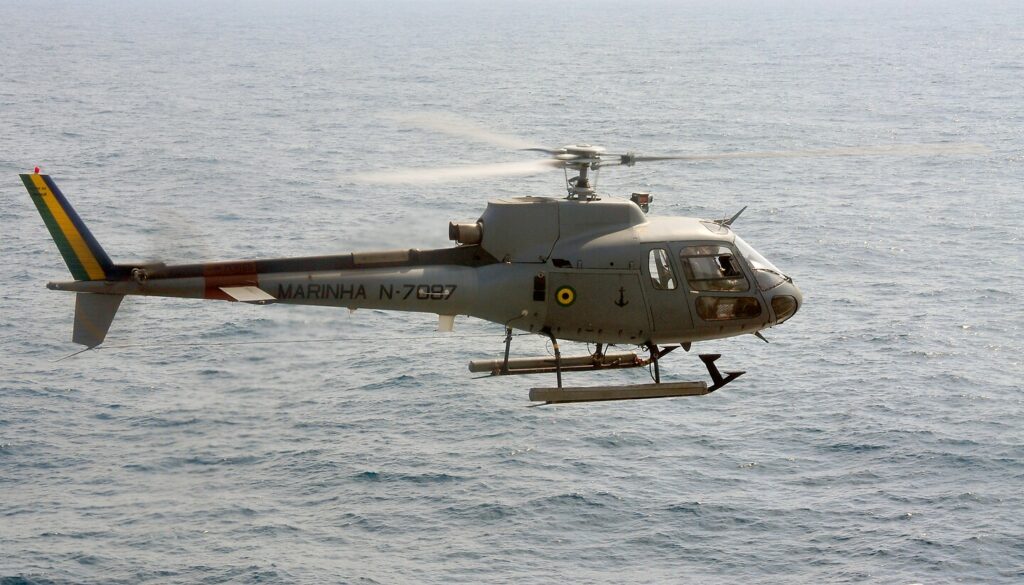 A Brazilian Armed Forces H125 helicopter in flight over water.