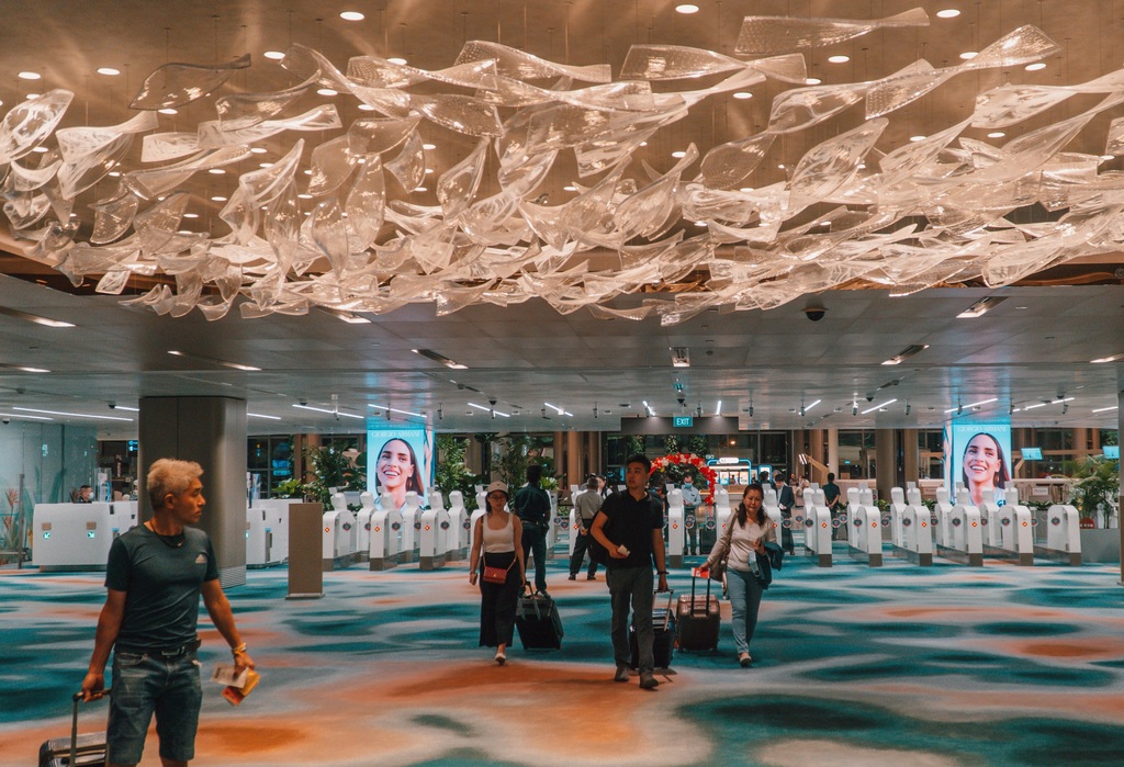 Passengers pass through departure processing in Singapore Changi Airport T2 facility.