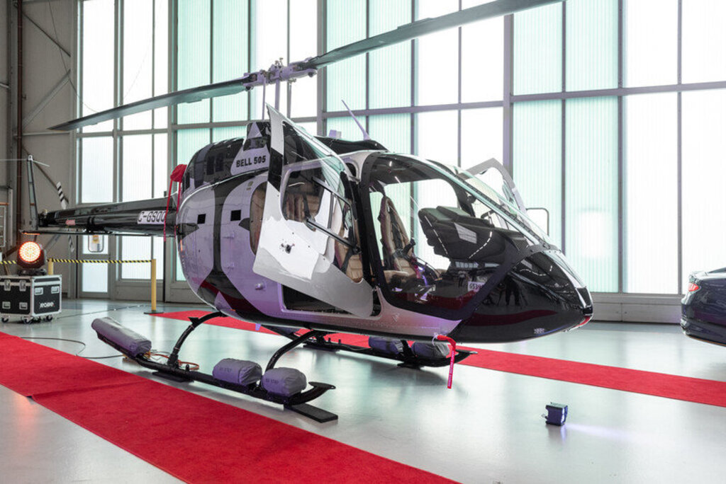 A Bell Textron Bell 505 helicopter parked inside a showroom.