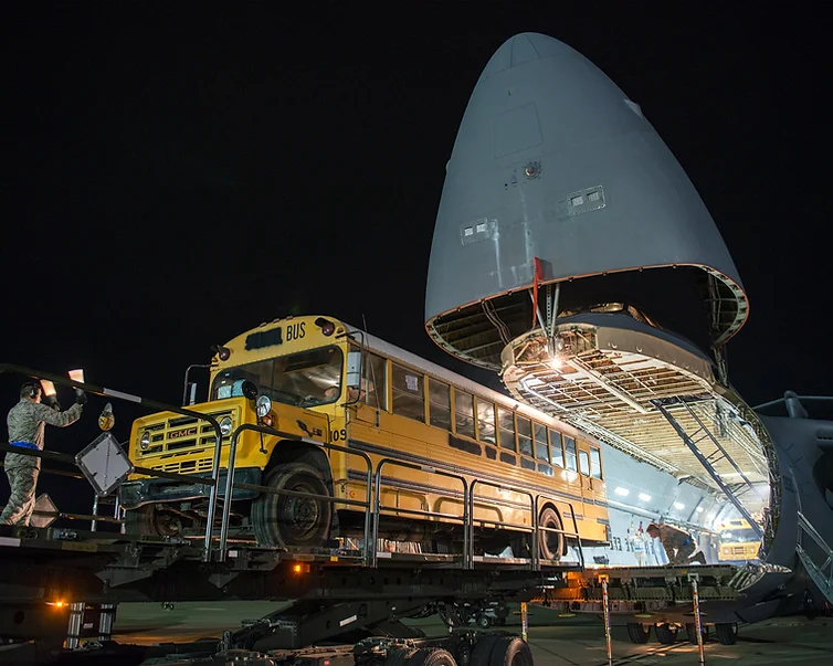 A school bus bound for Haiti is loaded aboard a USAF C-17 Globemaster.