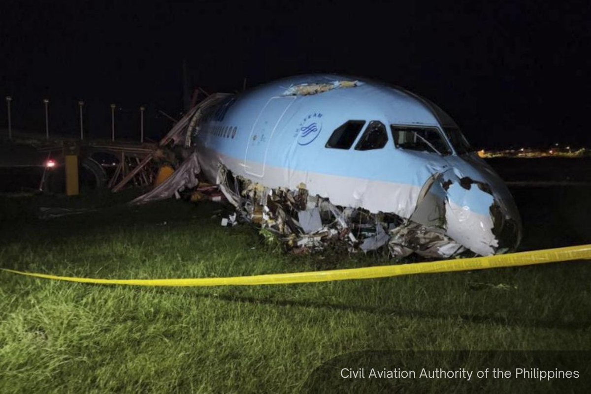 A heavily damaged Korean Air aircraft lies in grass at Philippines Mactan-Cebu airport.