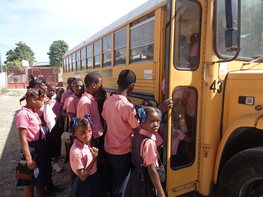 School children board the donated bus in Haiti.
