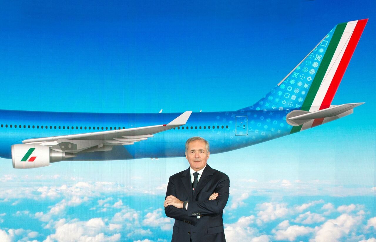 ITA Airways Executive President poses in front of ITA aircraft picture.
