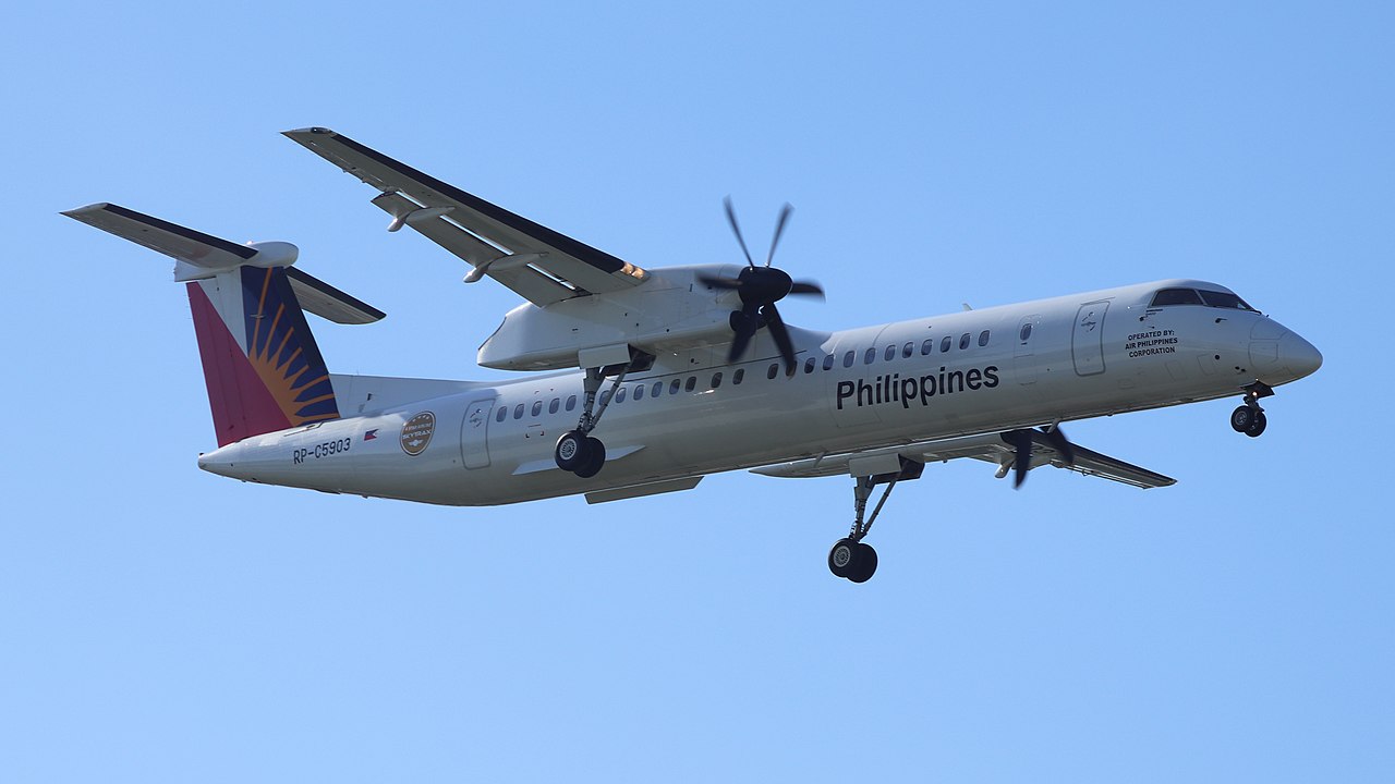 A Philippine Airlines Dash 8-400 aircraft passes overhead