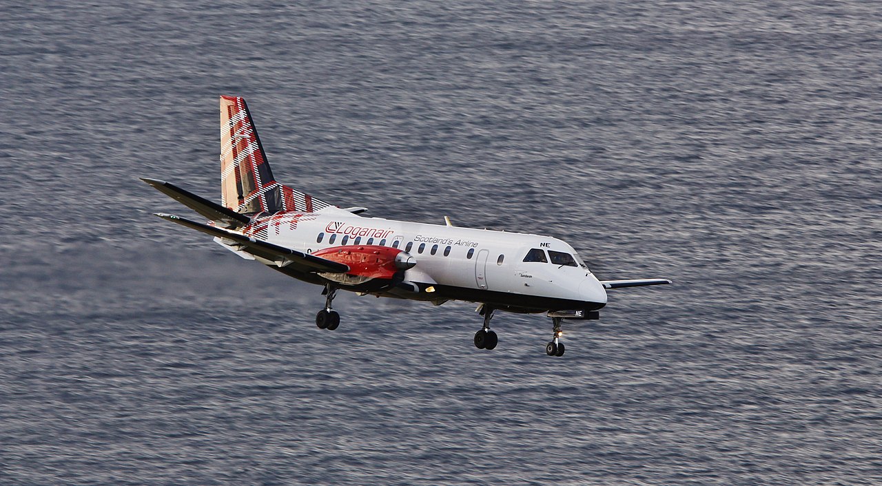 A Loganair aircraft banks over water as it approaches to land.