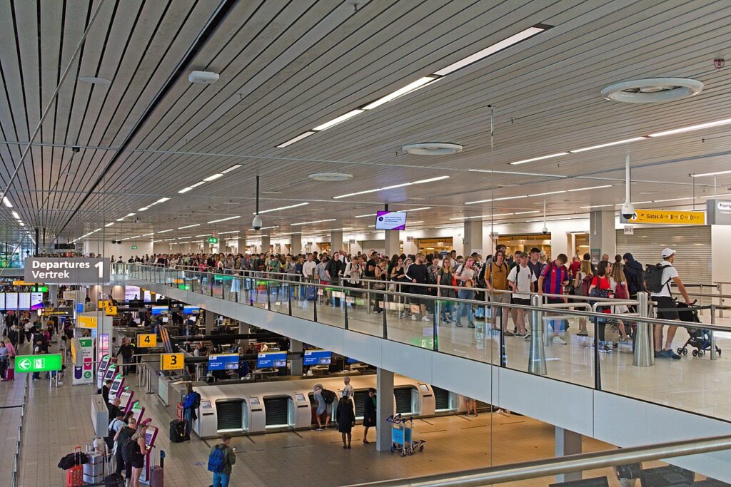 Queues of people at Schiphol Airport security control.