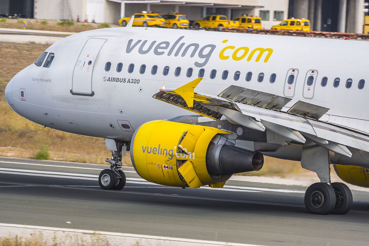A Vueling aircraft with wing spoilers extended.