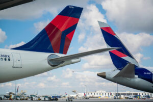 The tail fins of a Delta Air Lines plane and a LATAM Airline plane side by side.