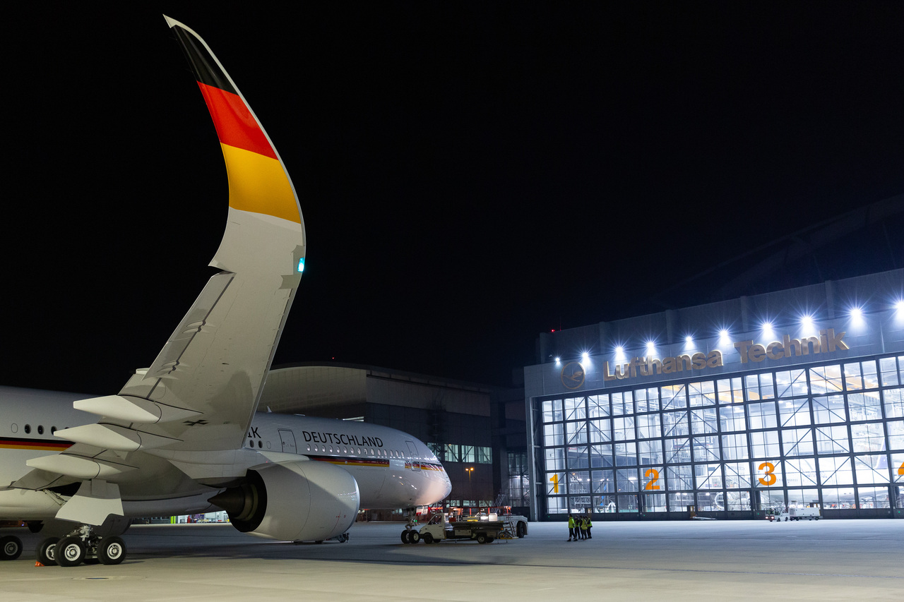 The new German Armed Forces A350 aircraft parked at night outside the Lufthansa Technik hangar.