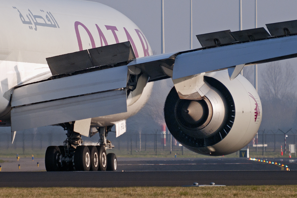 A Qatar Airways Cargo aircraft with wing spoilers extended.
