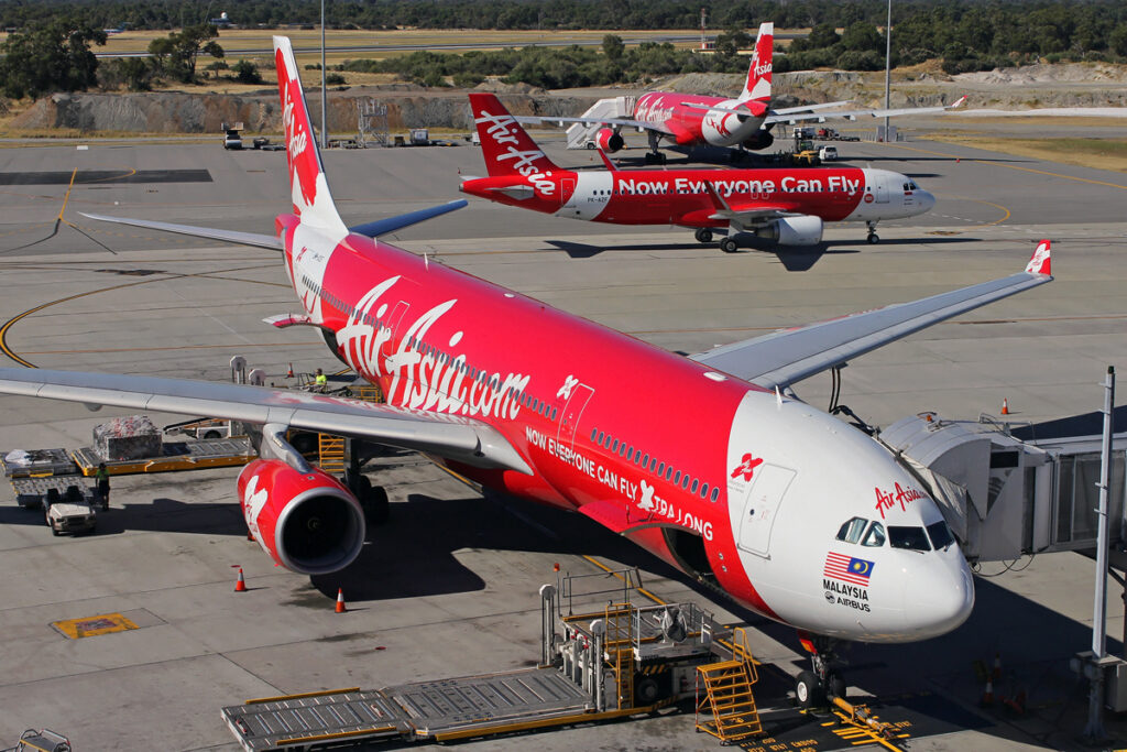 Three AirAsia aircraft parked on the tarmac at Perth Airport.