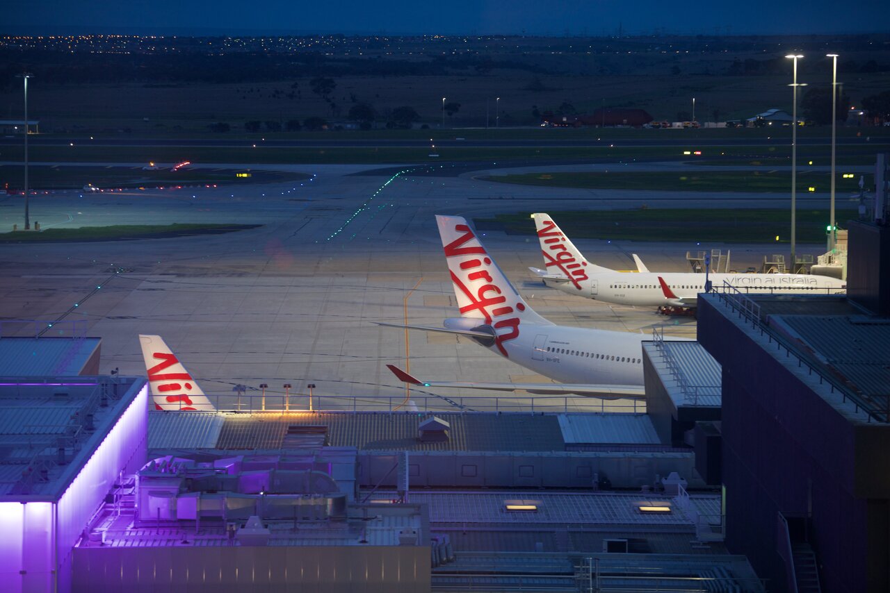Virgin Australia aircraft parked at Melbourne Airport at night.