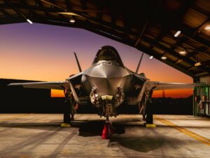An RAAF F-35A fighter in the hangar at sunset