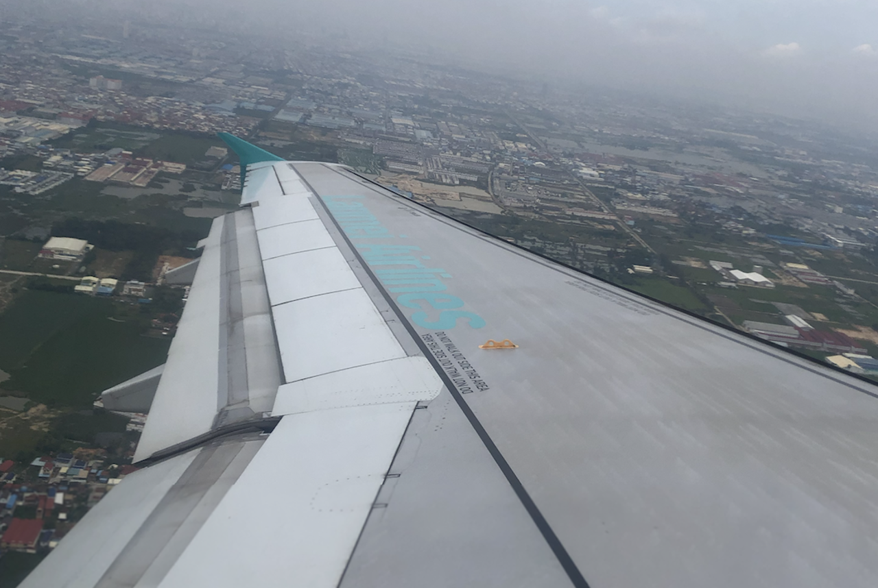 View across the wing of a Lanmei Airlines Airbus in flight.
