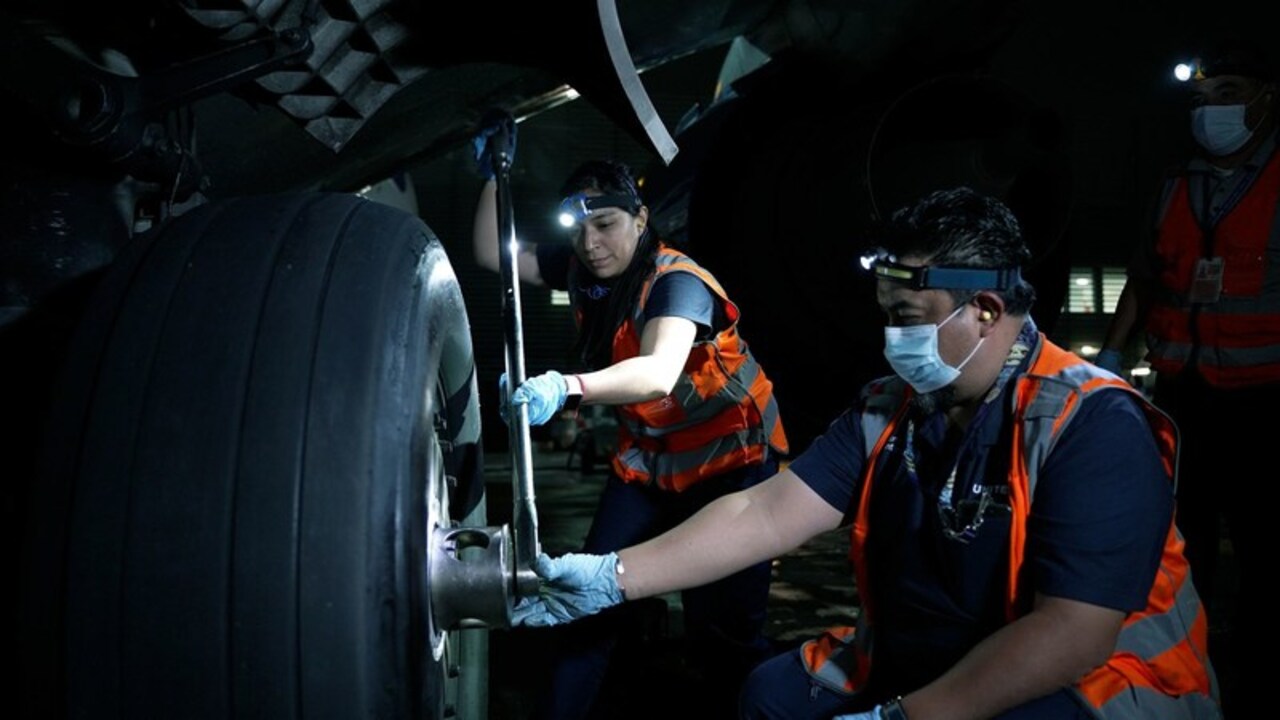 United Airlines engineers work on an undercarriage wheel.