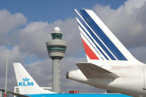 Aircraft tails in front of the Amsterdam Schiphol Airport control tower.