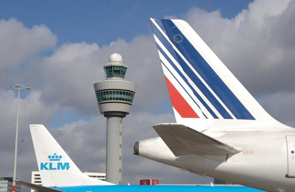 Aircraft tails in front of the Amsterdam Schiphol Airport control tower.