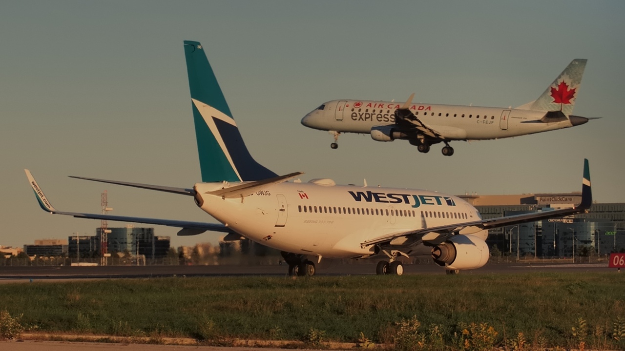 A WestJet Boeing waits for an Air Canada flight to land.