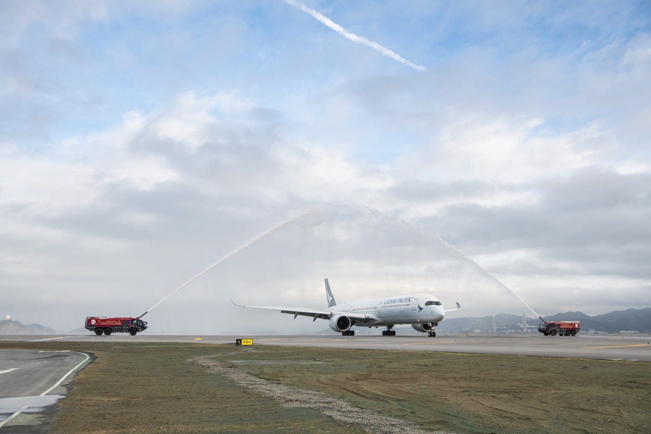 A Cathay Pacific Airbus A350 receives a water cannon salute after opening Hong Kong International Airport's third runway.