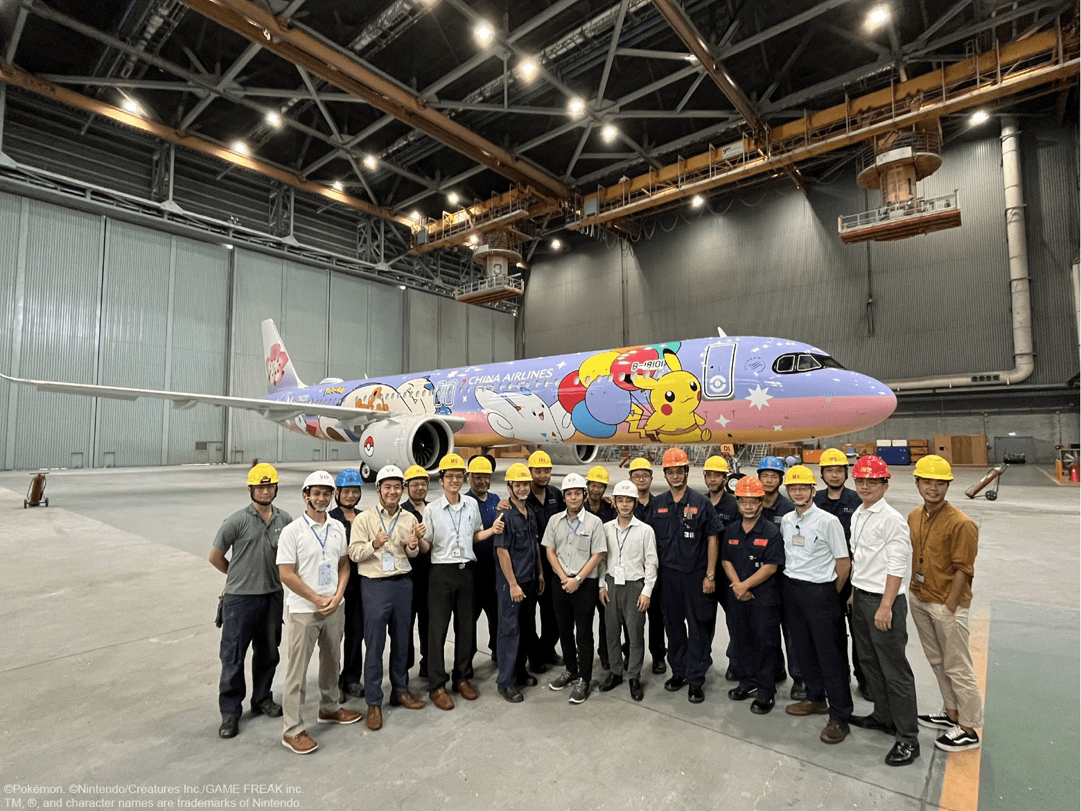 China Airlines team stand in front of the customized 'Pikachu Jet CI' in the hangar